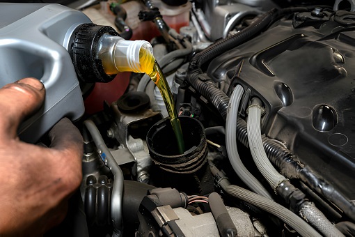 Mechanic Pours New Car Oil Into The Engine
