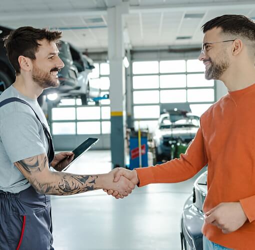 Car Owner Shaking Hands With Car Mechanic