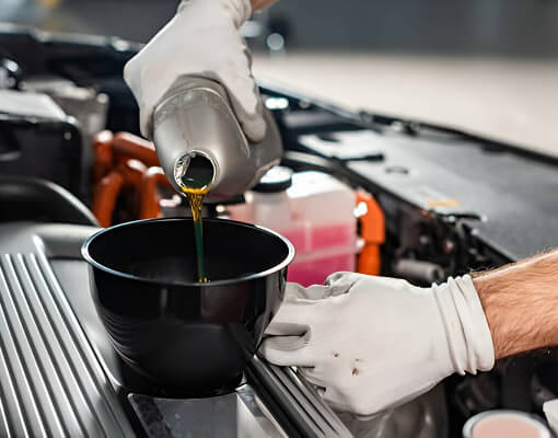 Mechanic Pouring Oil To Car Engine